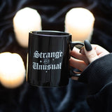 Ceramic mug with 'Strange and Unusual' in gothic lettering, 300ml capacity, perfect for dark-themed beverage lovers.