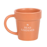 Alt text: Quirky ceramic plant pot mug with mini shovel spoon, featuring "Head Gardener" design for garden enthusiasts.