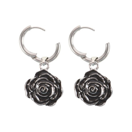 Intricately designed stainless steel rose earrings dangling from hoops, adding edgy elegance to any outfit.