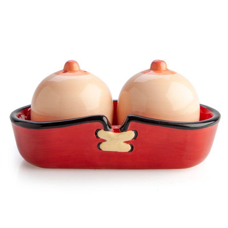 Whimsical ceramic salt and pepper shakers shaped like breasts, complete with a corset tray for organization.