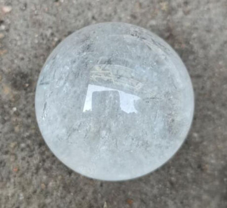 Clear quartz sphere (4cm) radiating positive energy, ideal for home decor, meditation, and crystal healing.