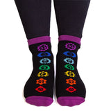 Vibrant rainbow socks featuring chakra symbols and anti-slip words "CHAKRAS ALIGNED" for comfort and spiritual expression.