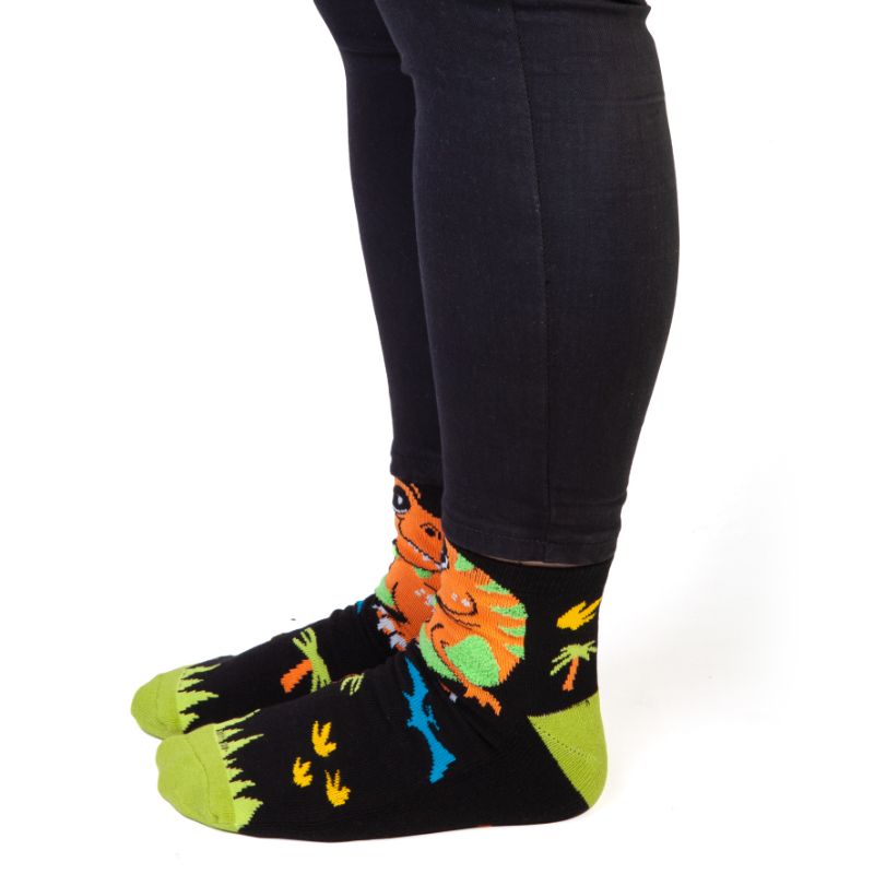 Cozy T-Rex Feet Speak socks with vibrant stripes, 'BITE ME' pun, and anti-slip soles, perfect for dinosaur lovers.