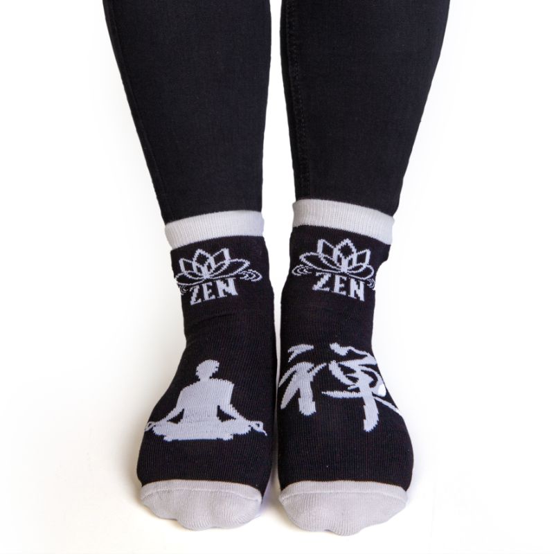 Black socks with a grey meditating silhouette, featuring anti-slip design for comfort and safety, ideal for yoga and relaxation.