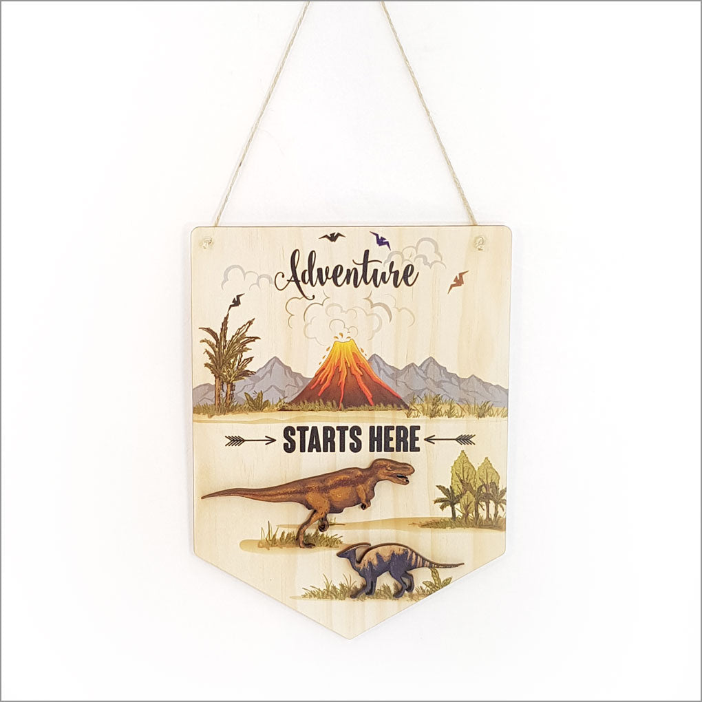 Printed pine flag wall art featuring "Adventure Starts Here," promoting exploration with vibrant colors and eco-friendly materials.