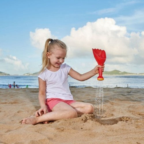 Bright red Hape Rain Shovel beach toy for toddlers, ideal for outdoor play with sand and water, promoting creativity and motor skills.