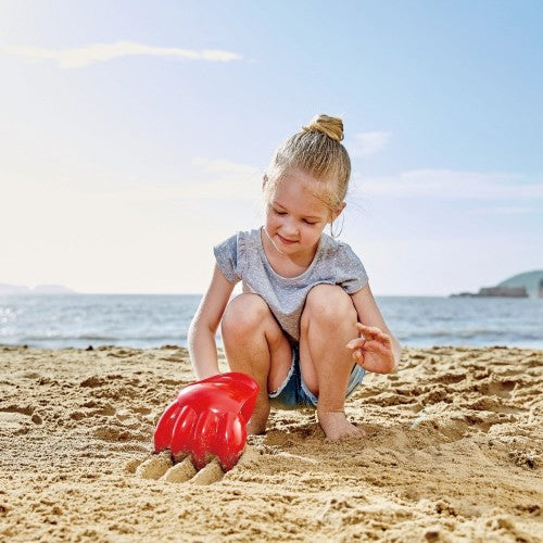 Bright red Hape Power Paw Toy for toddlers, perfect for outdoor sand and water play, encouraging creativity and active exploration.