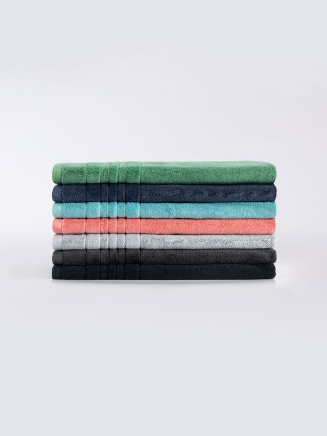 Soft SEAGLASS bath mat by Savona features luxurious 900 GSM cotton and chic velour striped hem for elegant bathroom decor.
