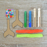 Colorful craft kit for kids to create unique mermaid peg dolls with sparkles, glitter, and easy instructions for ages 5+.