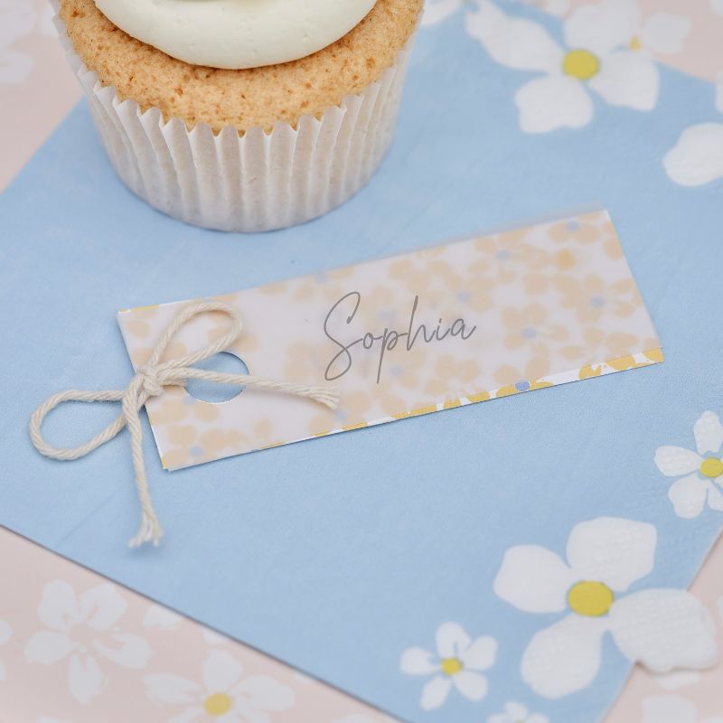 Floral place cards in pastel colors, featuring vellum paper and cream twine, perfect for elegant events and sustainable styling.