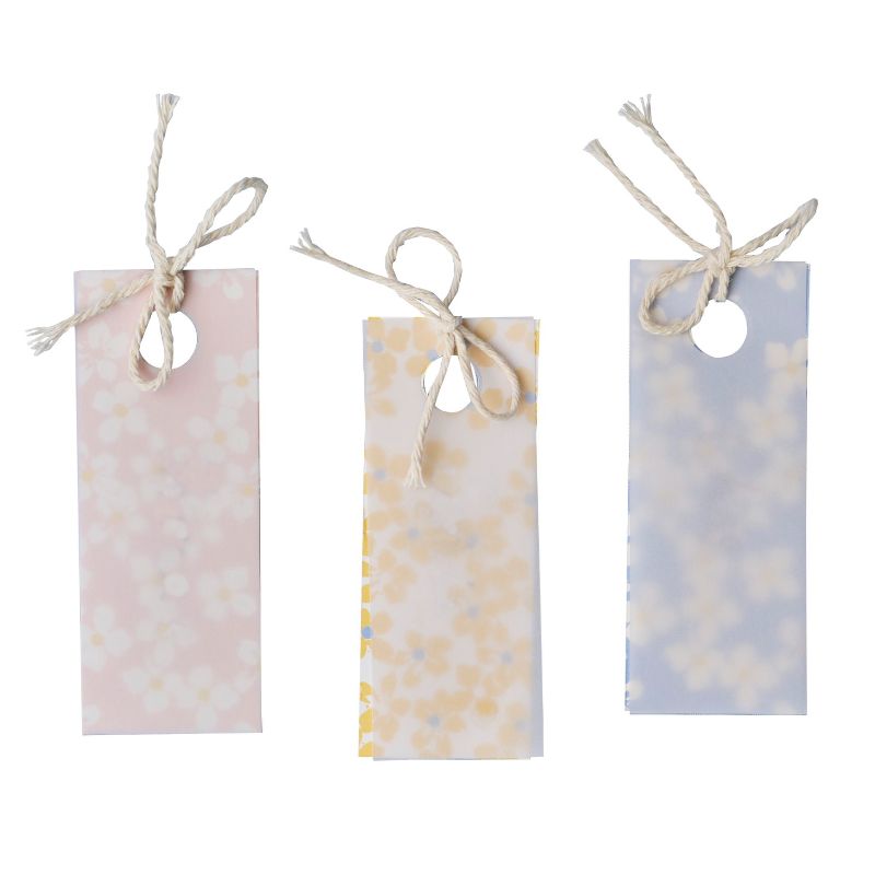 Elegant floral place cards made of vellum paper, perfect for weddings and events, featuring pastel colors and cream twine.