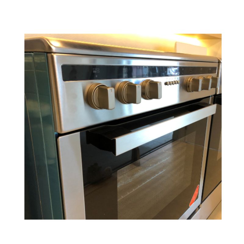 Midea 60cm Induction Freestanding Cooker with sleek glass cooktop, 4 induction burners, and 70L multi-function oven.