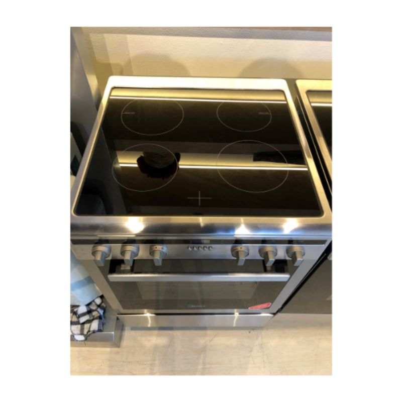 Midea 60cm Induction Freestanding Cooker with 4 burners, 70L oven, and safety features in a sleek design.