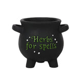 Small cauldron-shaped plant pot with 'Herbs for spells' text and star accents, ideal for growing herbs and witchy decor.