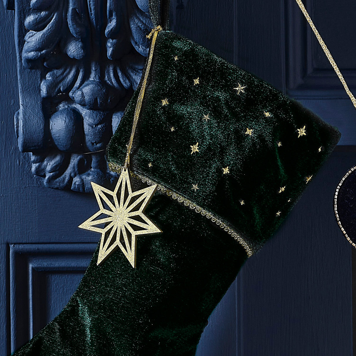 Velvet Luxe green Christmas stocking with wooden gold star charm, perfect for festive decor and sustainable holiday traditions.