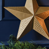 Luxurious gold metal star decoration with a hammered texture, perfect for festive displays and eco-friendly holiday décor.