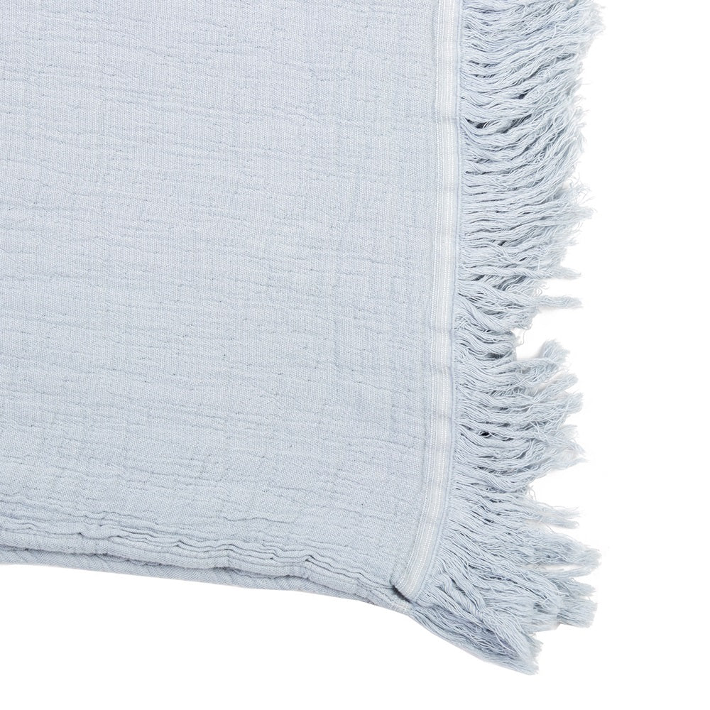 Luxurious stonewashed cotton throw in quarry color with embossed pattern and fringed edges, perfect for cozying up in style.