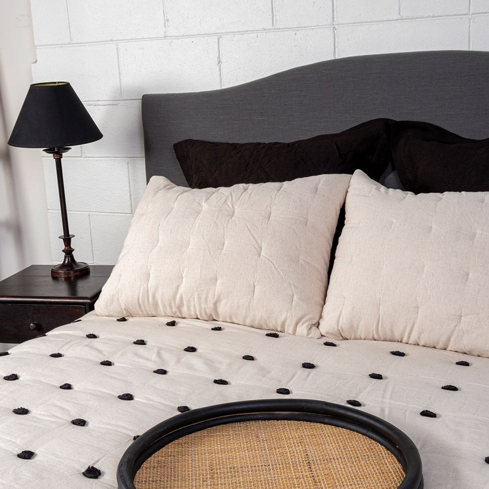 Luxurious black quilt with playful pom poms, made from cotton/linen blend, size 260 x 240 cm, perfect for chic bedroom decor.