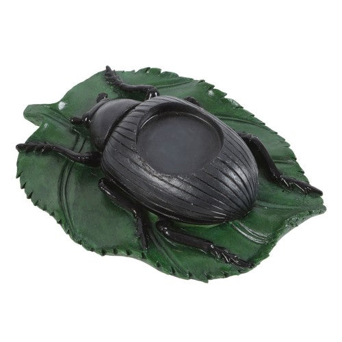 Intricate black beetle tealight candle holder on a green leaf, perfect for unique home decor and creating a mesmerizing ambiance.