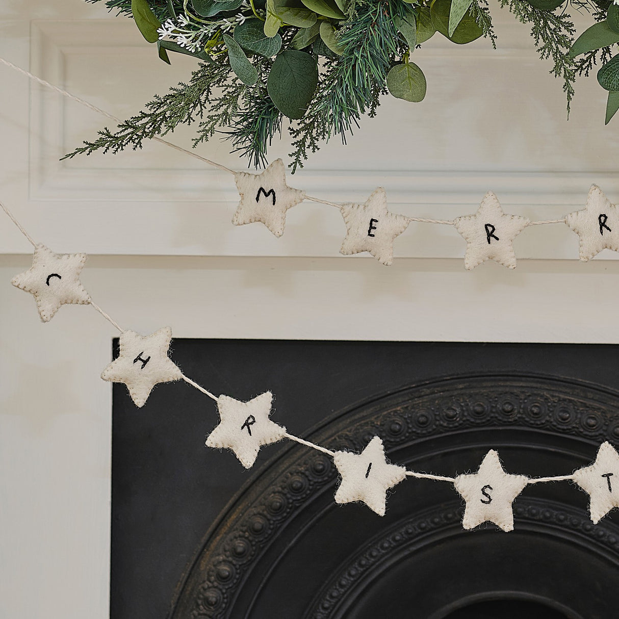 Handmade felt Christmas bunting featuring white stars, perfect for festive decor, eco-friendly and supporting local craftswomen.