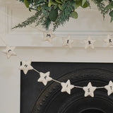 Handmade felt Christmas bunting featuring white stars, perfect for festive decor, eco-friendly and supporting local craftswomen.