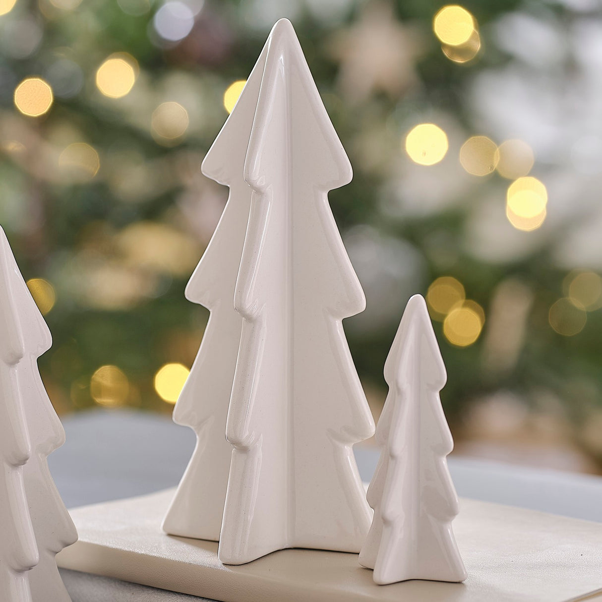 Set of three white ceramic Christmas trees in varying sizes, ideal for festive home decor and celebrating a White Christmas.