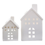 White ceramic house tealight holders, small and large, creating a cozy ambiance for holiday decor. Tealights not included.