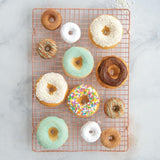 Vibrant red Nordic Ware Mini Donut Pan, baking 12 mini donuts in durable aluminum, perfect for charming homemade treats.