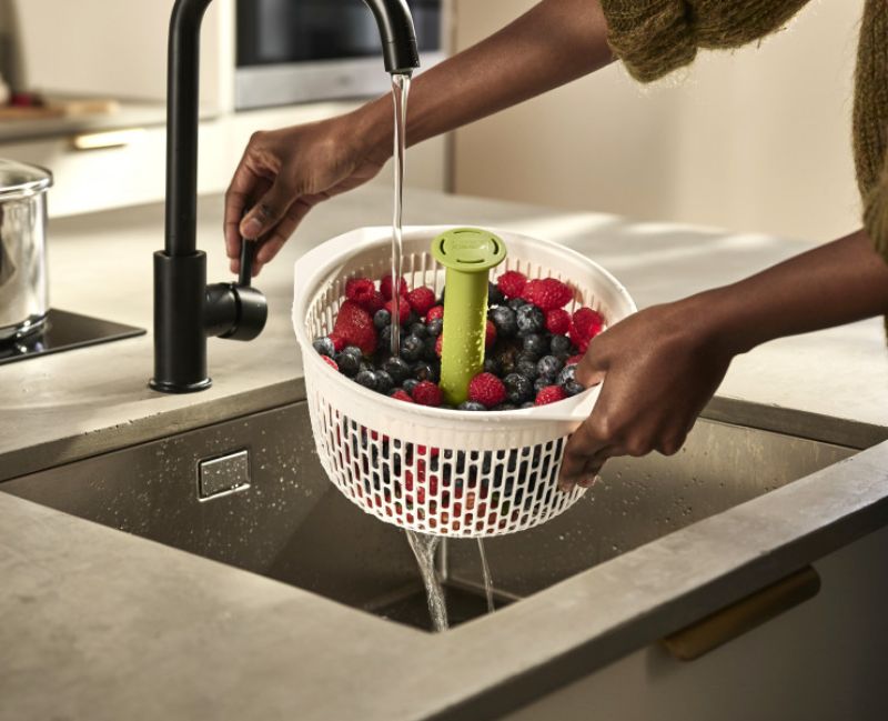 Innovative Joseph Joseph Spindola colander spins to dry vegetables; compact, easy to clean, and features a secure suction base.