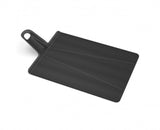 Large black folding chopping board with a textured surface and non-slip feet for easy ingredient transfer and cleanup.