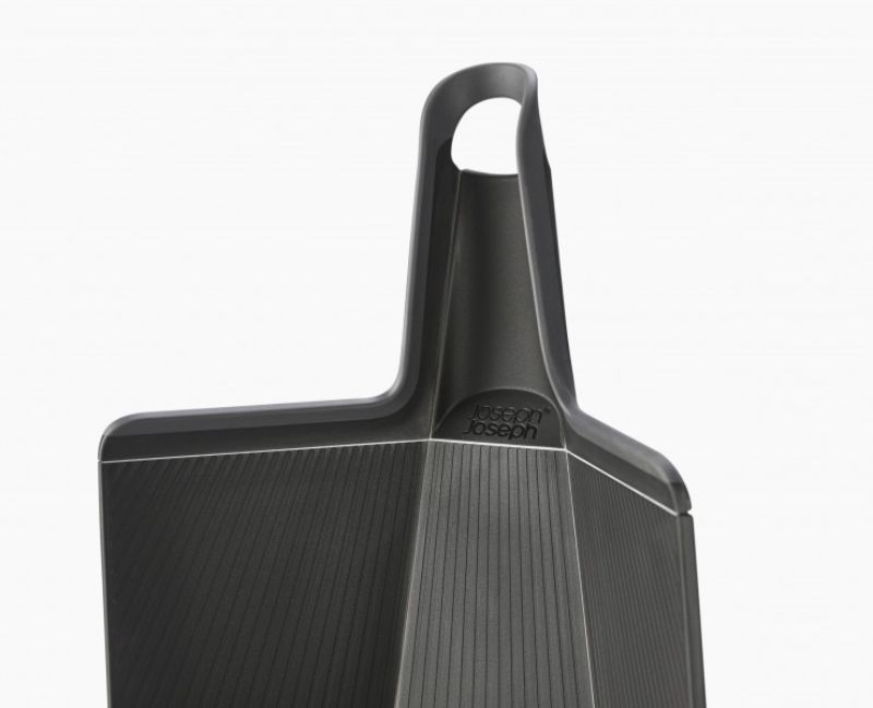 Innovative folding black chopping board with non-slip feet and a soft-grip handle for easy ingredient transfer.