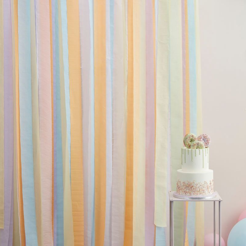 Pastel streamer party backdrop featuring pink, yellow, lilac, peach, and blue for vibrant celebrations and photo opportunities.