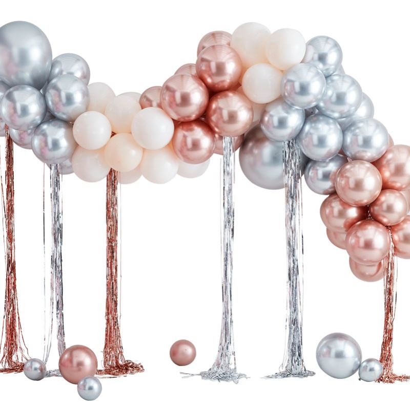 Mixed metallics balloon arch featuring silver, rose gold, and cream balloons with streamers, perfect for party entrances.