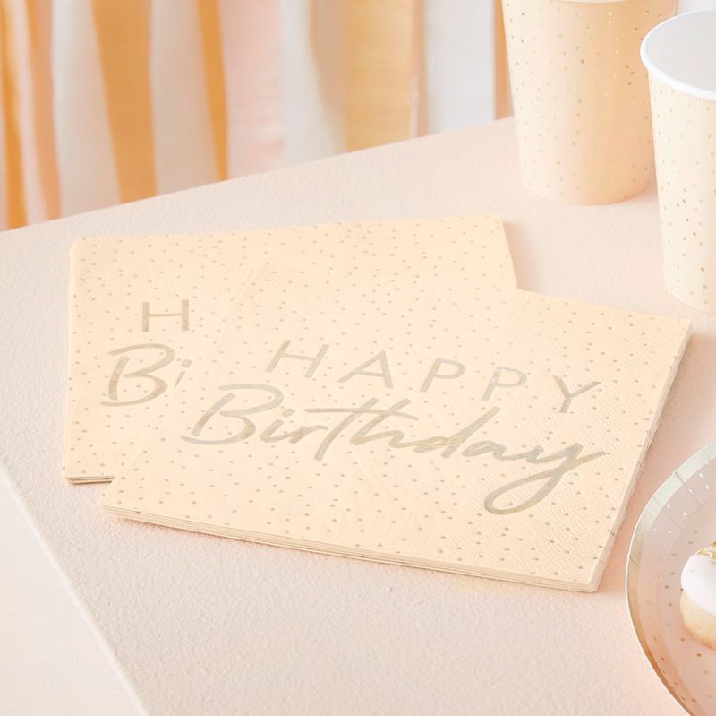 Peach and gold party napkins with polka dots and 'Happy Birthday' in gold foil, perfect for festive celebrations.