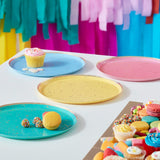 Brightly colored party plates with gold flecks, featuring red, yellow, blue, and teal designs for vibrant celebrations.