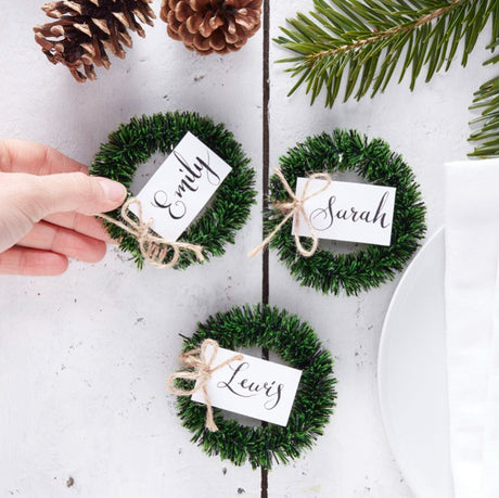 Mini rustic wreath place card holders for Christmas tables, adding charm and personalized seating for guests.