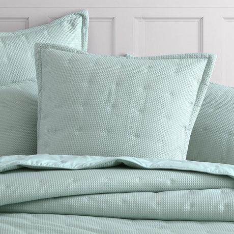 European pillowsham with a textured waffle weave, quilted design, and flanged trim for elegant bedroom decor.