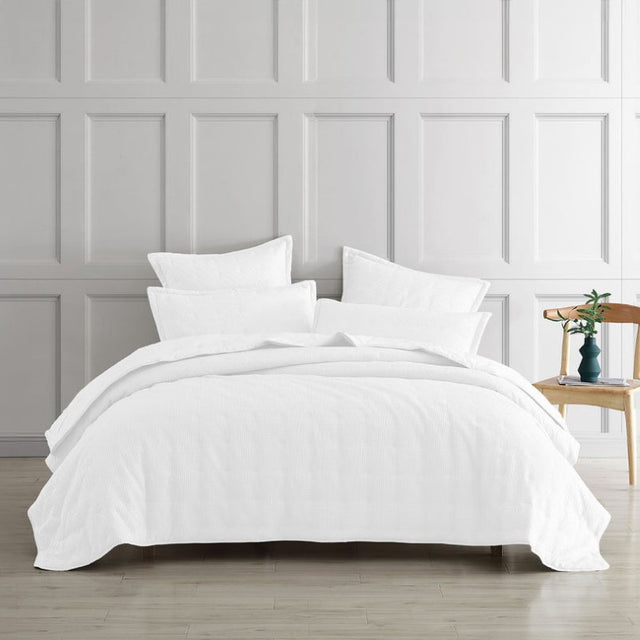 Luxurious white quilted coverlet with textured waffle weave, perfect for single or double beds, combining elegance and comfort.