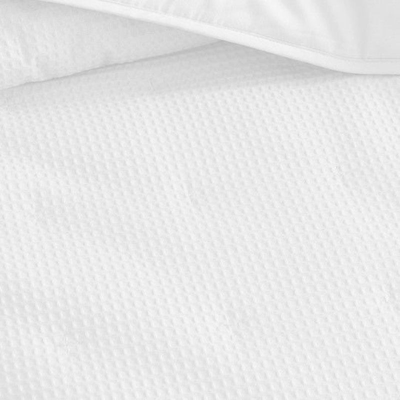 Textured waffle weave coverlet in classic white, perfect for single or double beds; luxurious, durable, and machine washable.