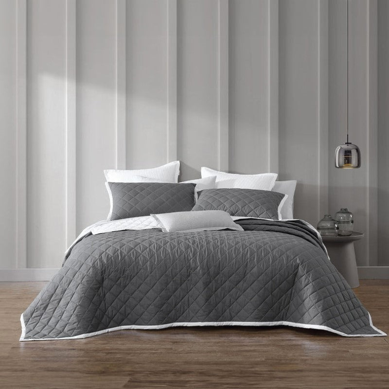 Quilted Logan & Mason Essex Charcoal bedspread in herringbone design, perfect for queen beds, with white bound edge.