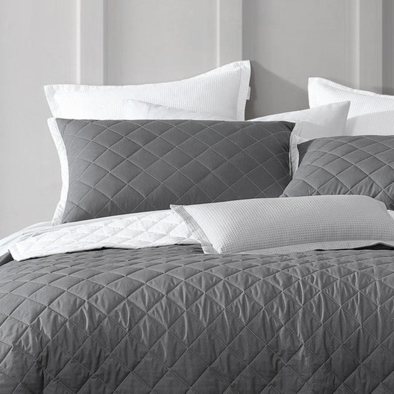 Elegant quilted bedspread in charcoal with herringbone design and white bound edge, perfect for queen-sized beds.