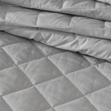 Elegant Logan & Mason Essex Pewter bedspread with quilted herringbone design, white bound edge, perfect for queen beds.