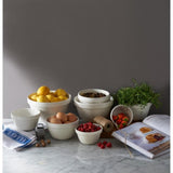 Mason Cash 14cm white pudding basin with protruding rim, vented base, and ceramic construction for versatile cooking.