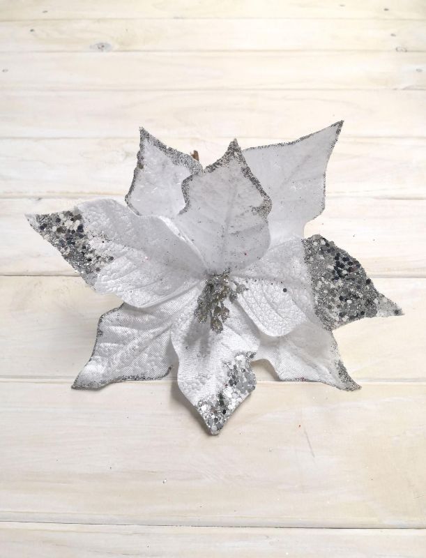 Silver artificial poinsettia with glittered petals and sequins, perfect for elegant holiday decorations and centerpieces.
