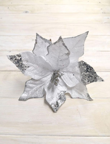 Silver artificial poinsettia with glittered petals and sequins, perfect for elegant holiday decorations and centerpieces.