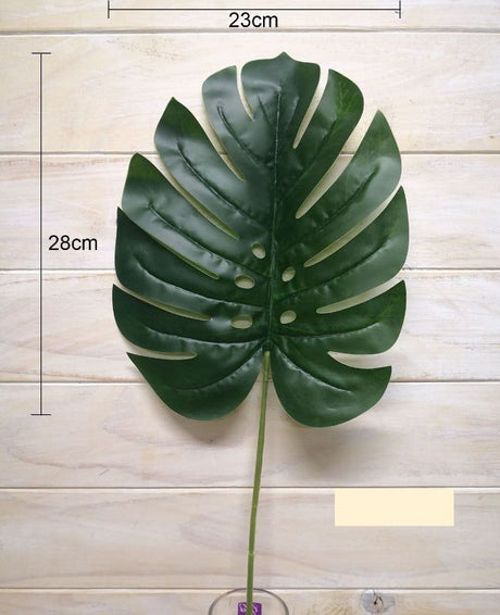 Vibrant green artificial monstera leaf adding tropical elegance to home decor, ideal for stylish arrangements and displays.