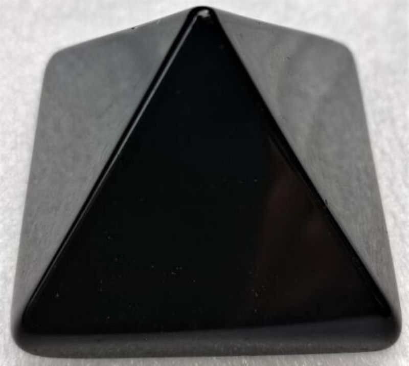 Sleek 4cm obsidian pyramid, showcasing volcanic glass beauty and protective qualities, perfect for decor and meditation.