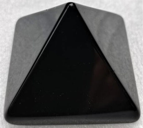 Sleek 4cm obsidian pyramid, showcasing volcanic glass beauty and protective qualities, perfect for decor and meditation.