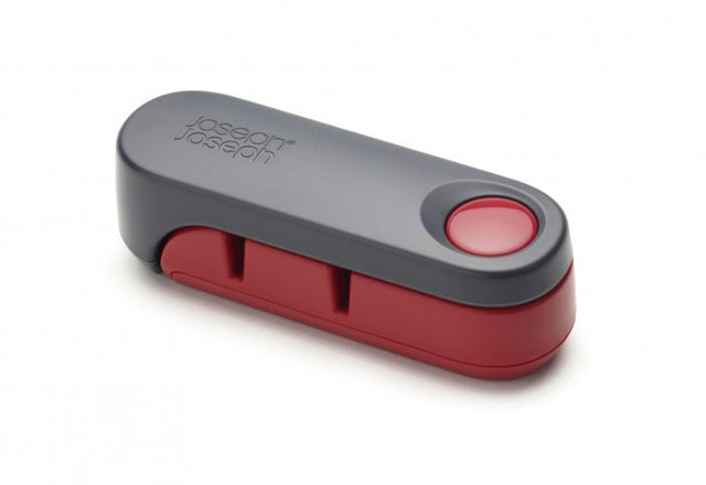 Joseph Joseph Rota knife sharpener in dark grey/red with ergonomic design, ceramic wheels for coarse/fine sharpening, compact for storage.