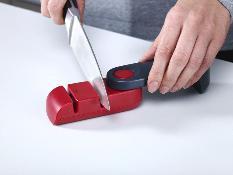 Joseph Joseph Rota knife sharpener in dark grey/red features a rotating design, ergonomic handle, and ceramic wheels for optimal sharpening.